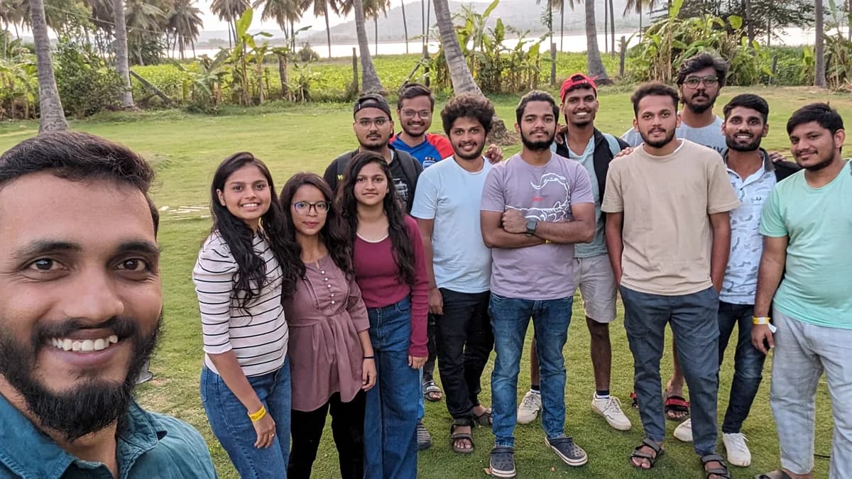 Creo teammates gathered on a palm-lined lawn during a company outing
