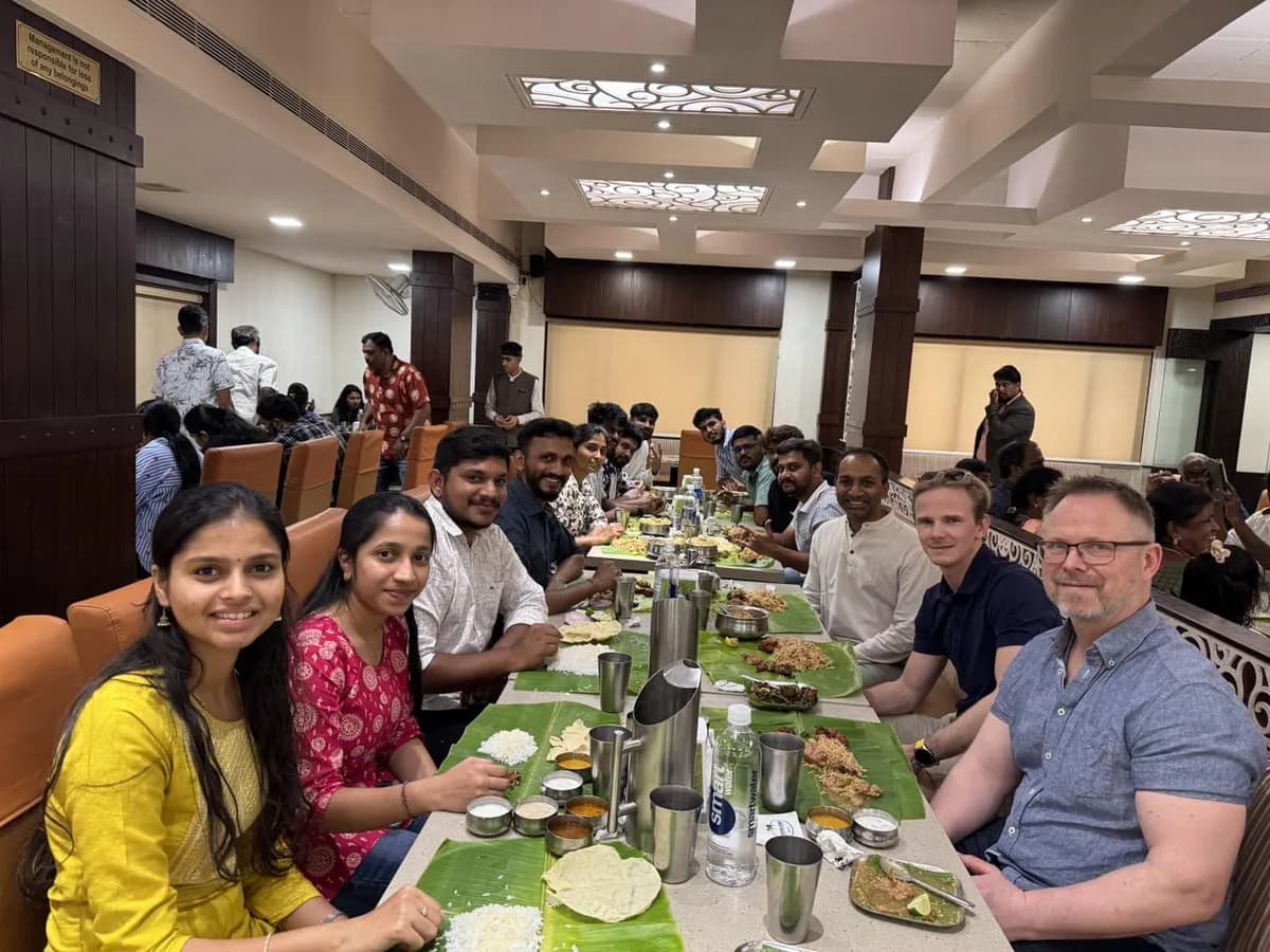 The Creo team sharing a meal around a long banquet table